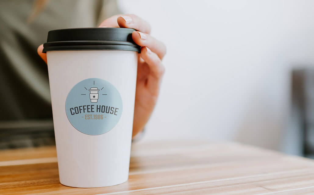 Kaffeehaus-Logo-Aufkleber auf einer Tasse.