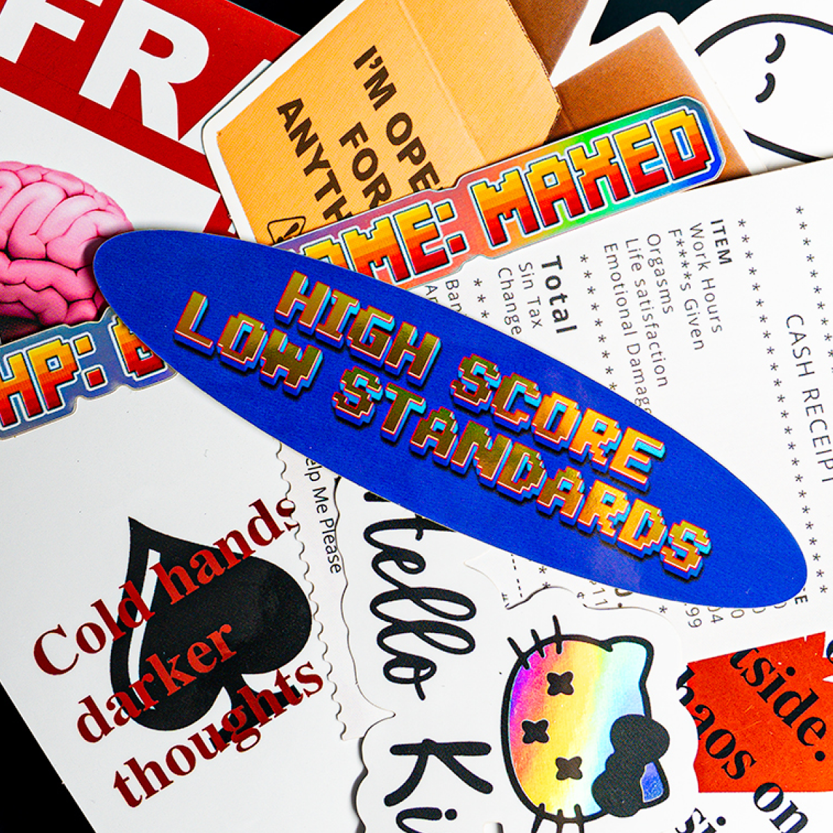 Haufen NSFW-Aufkleber, darunter ein blaues Oval "High score, low standards", eine "Hello Kinky"-Katze und Spielkartenmotive