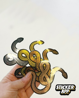 Hand hält Schlangen-Sticker aus gebürstetem Aluminium in Silber-, Gold-, Roségold- und Bronzetönen
