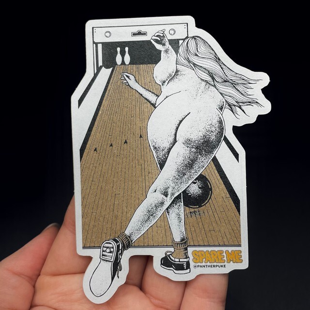 Eine Hand, die einen Kraftpapieraufkleber mit einer nackten Frau beim Bowling hält