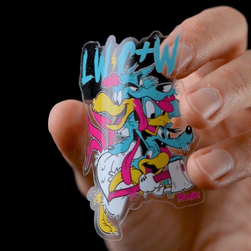 Eine Hand, die einen gestanzten, transparenten Aufkleber mit einer Cartoon-Figur mit einer Axt in der Hand hält.